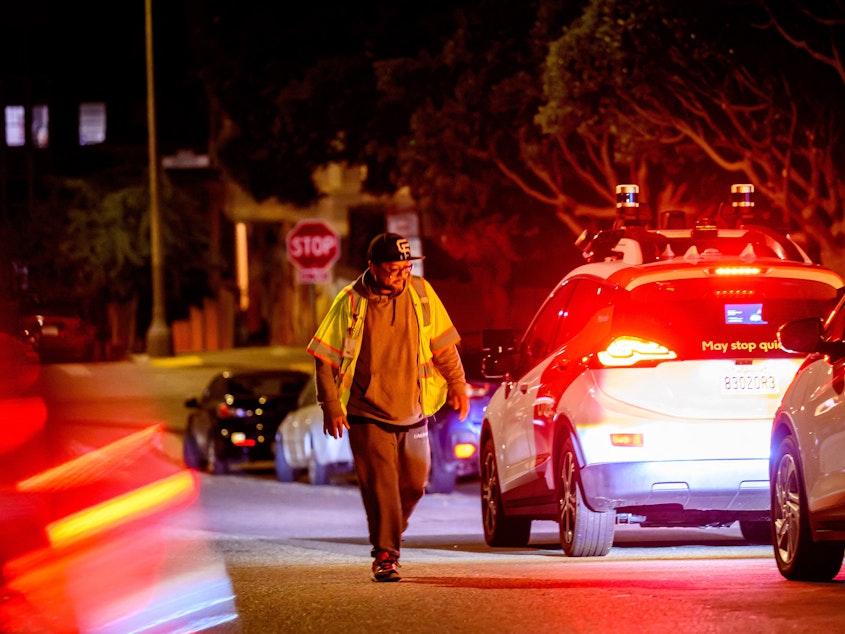 caption: A Cruise technician comes to restart a driverless car in San Francisco.