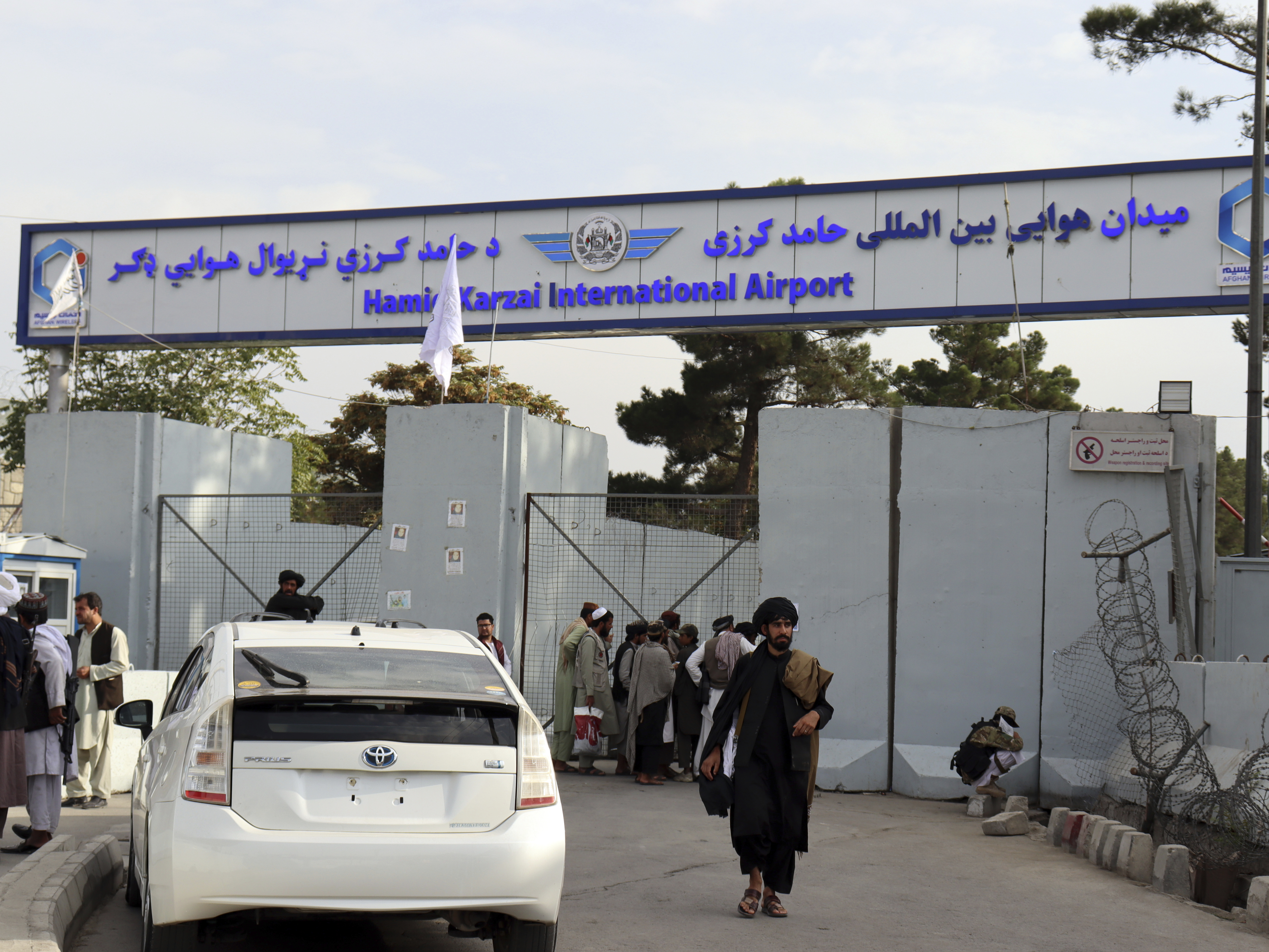 caption: Taliban fighters stand guard in front of the Hamid Karzai International Airport after the U.S. withdrawal in Kabul, Afghanistan.