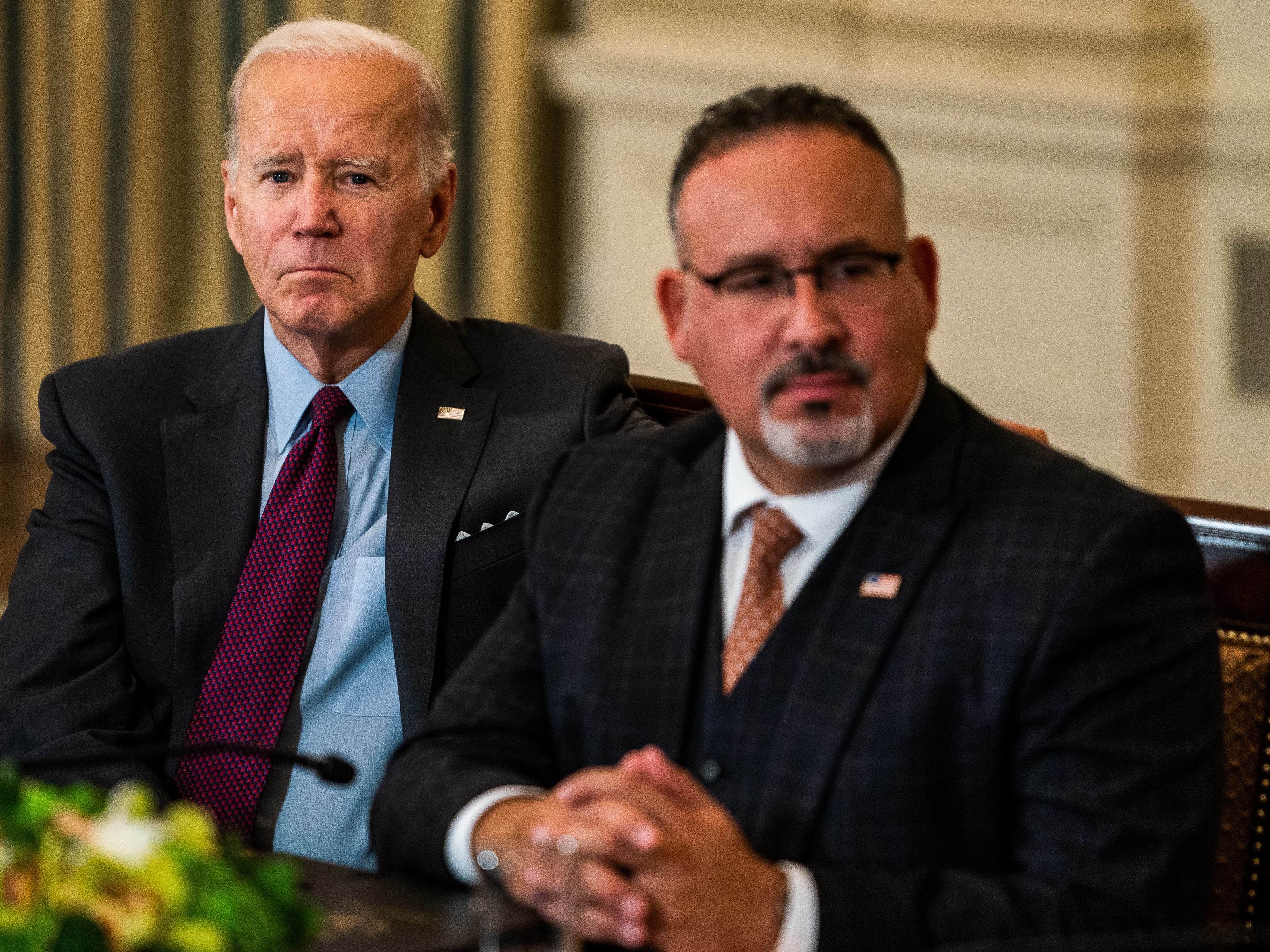 caption: President Joe Biden pictured with his Department of Education secretary, Miguel Cardona, in October 2022.