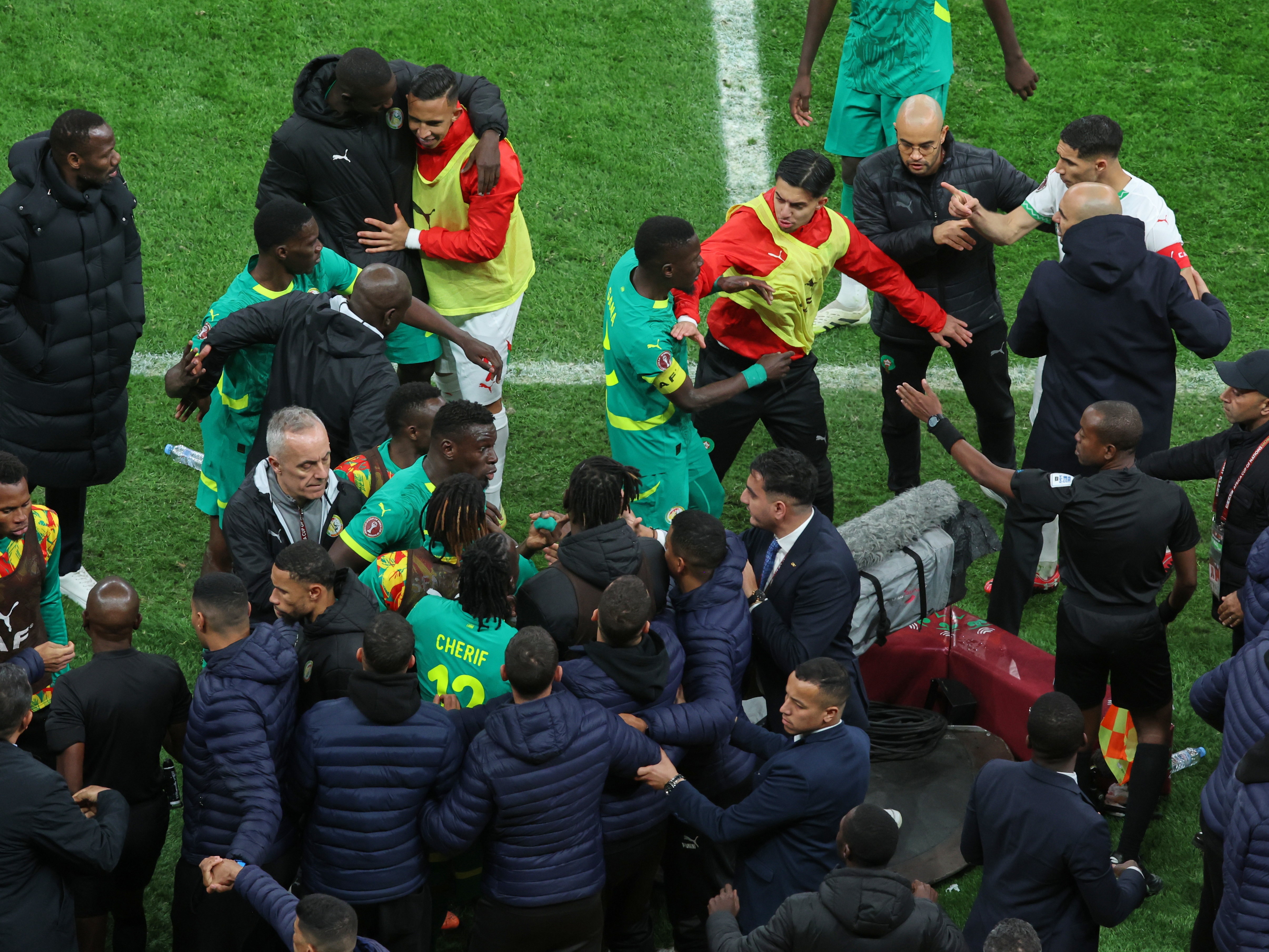 caption: Players from both sides clash after a controversial penalty was awarded to Morocco late on during the Africa Cup of Nations final soccer match between Senegal and Morocco in Rabat, Morocco, Sunday, Jan. 18, 2026.
