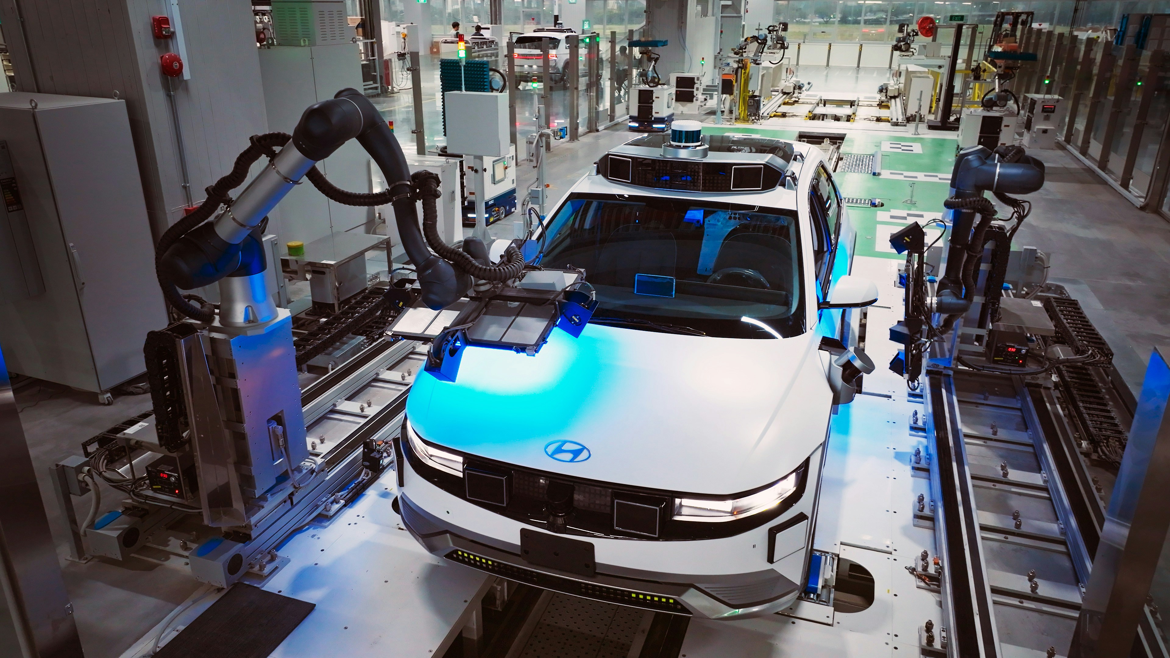 caption: A Hyundai IONIQ 5 robotaxi inside a factory.