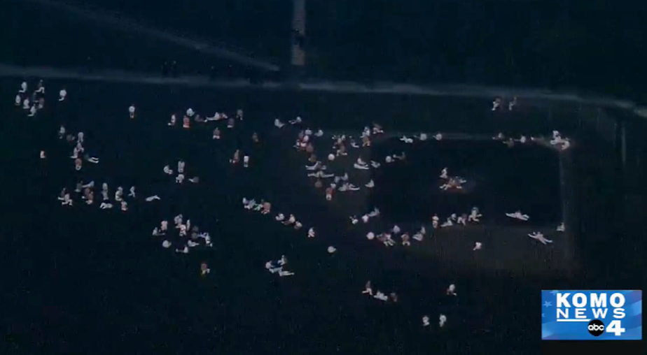 caption: This image from KOMO TV shows inmates at the Monroe Correctional Complex in the prison yard following a disturbance at the prison Wednesday night.