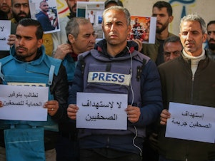 caption: Palestinian journalists stage a protest to draw attention to Palestinian members of the media killed while covering the war in the Gaza Strip on Jan. 15, in Rafah, Gaza.