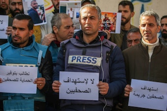 caption: Palestinian journalists stage a protest to draw attention to Palestinian members of the media killed while covering the war in the Gaza Strip on Jan. 15, in Rafah, Gaza.