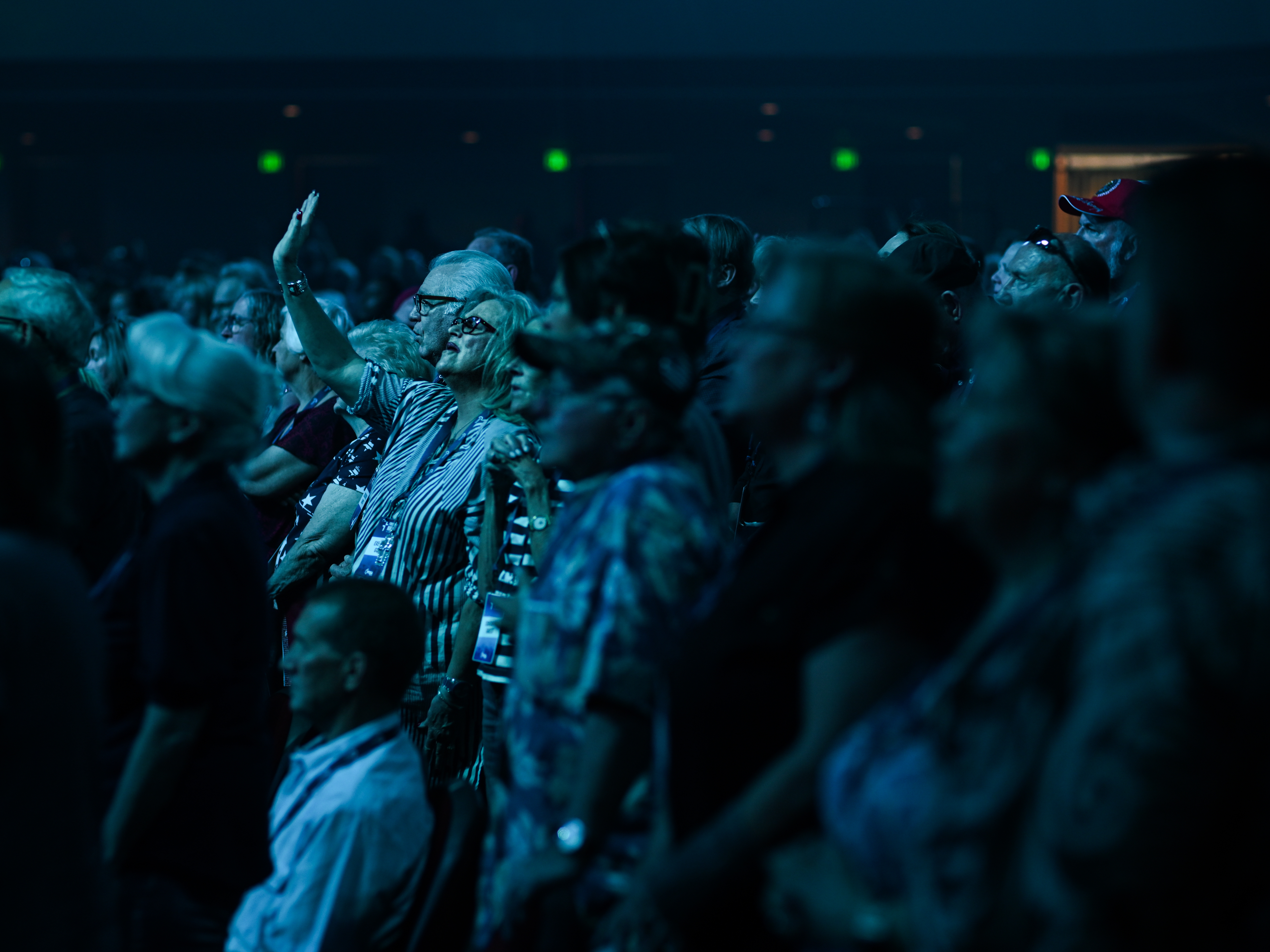 caption: Attendees sing praise songs before watching Turning Point's Charlie Kirk at Dream City Church in Phoenix on June 5.