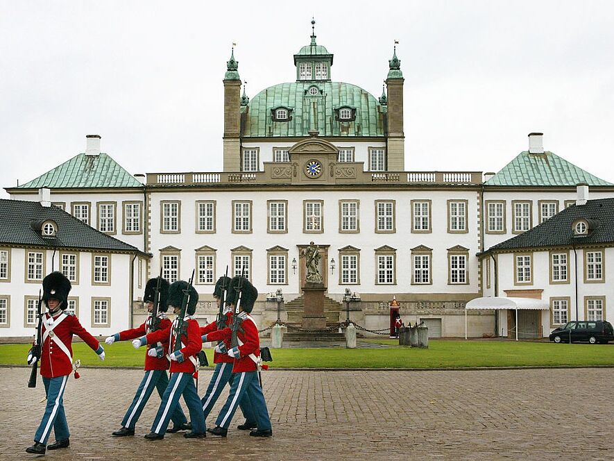 caption: Guards march in the courtyard of Fredensborg Palace in Denmark. The northern European country of around 6 million people has been suggested as a model for U.S. childhood vaccination policy.