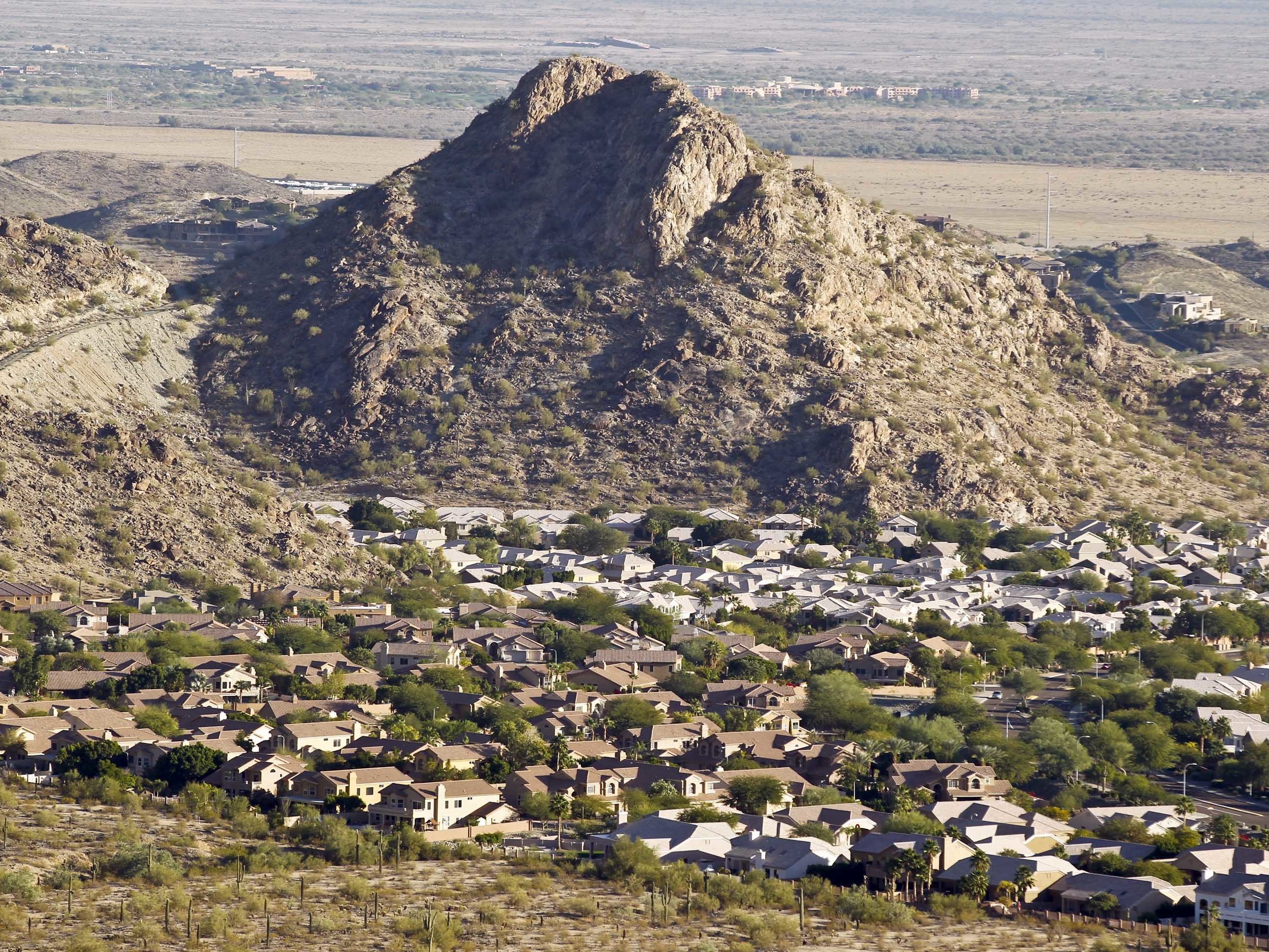 caption: A housing development sits nestled in the South Mountain foothills in the Ahwatukee neighborhood in Phoenix. The city saw the biggest jump in population in the U.S. between 2017 and 2018.