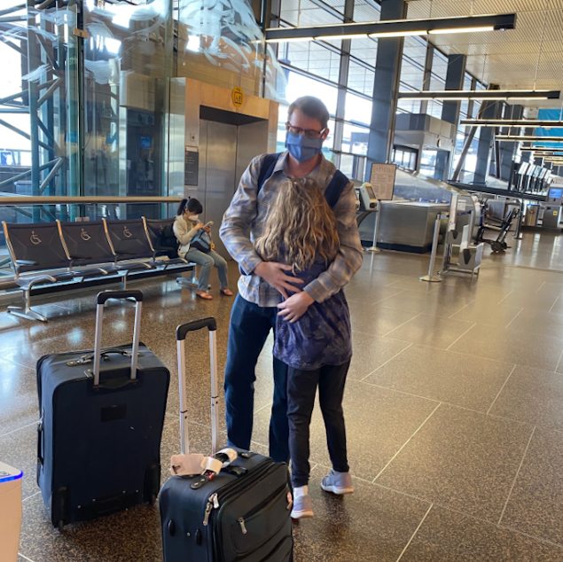 caption: Dr. Luke Hansen says goodbye to his nine-year-old daughter before boarding a plane to New York City in early April to volunteer his services at Elmhurst Hospital during the height of the COVID-19 outbreak.