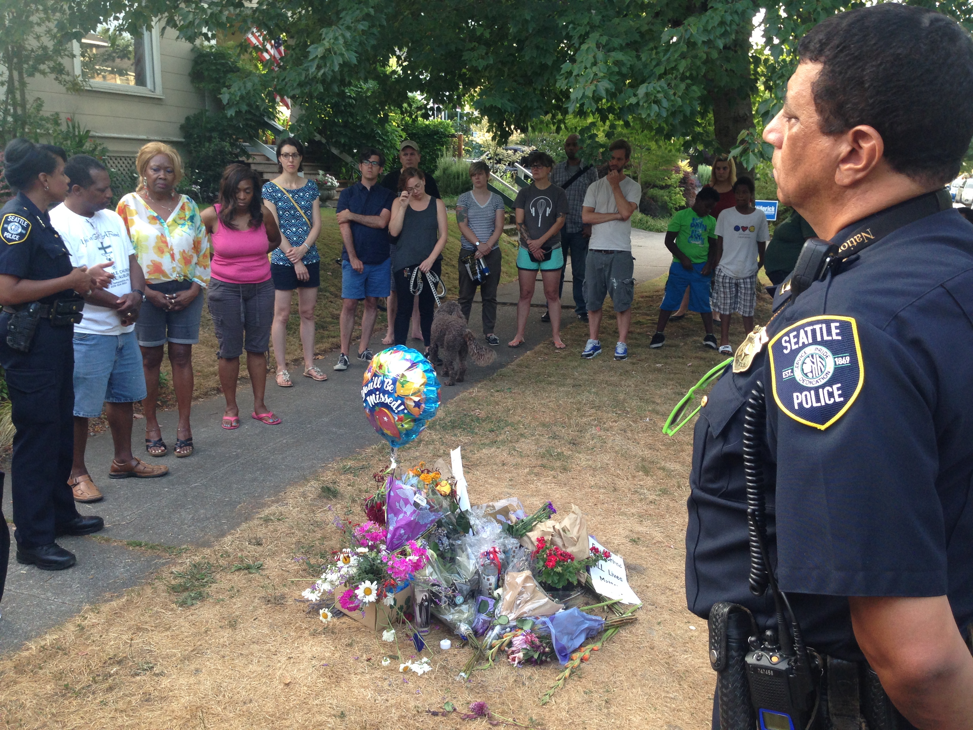 caption: Neighbors, police and pastors gather at a vigil for Torrence Spillers.