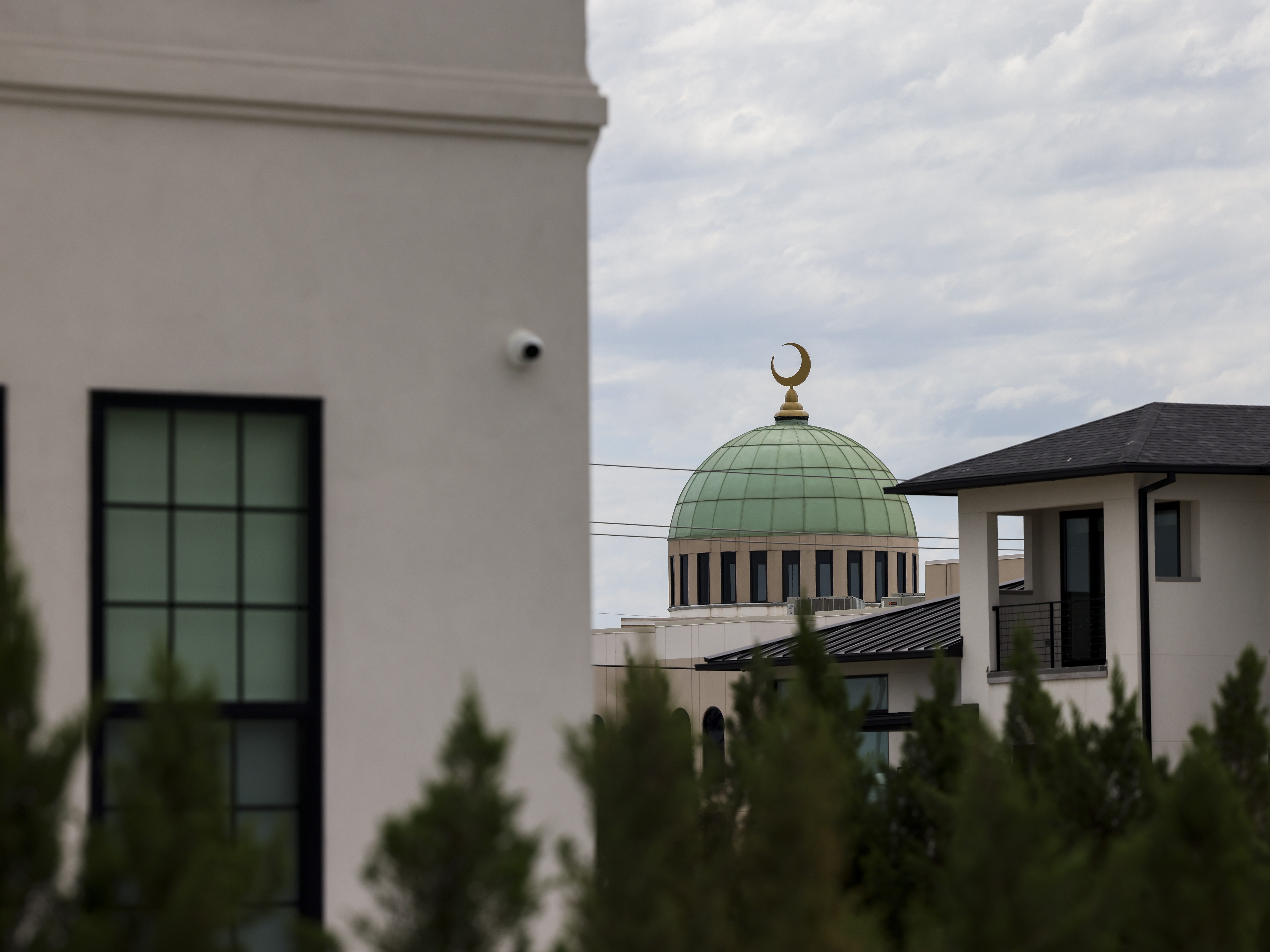 caption: The Plano EPIC mosque is seen behind a row of homes in Plano. Many muslims like to live near their mosque to facilitate practicing their faith daily.