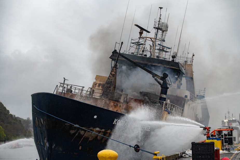 caption: The Kodiak Enterprise, weighed down by water used to fight a fire on board, lists to port on April 10 at the Port of Tacoma.