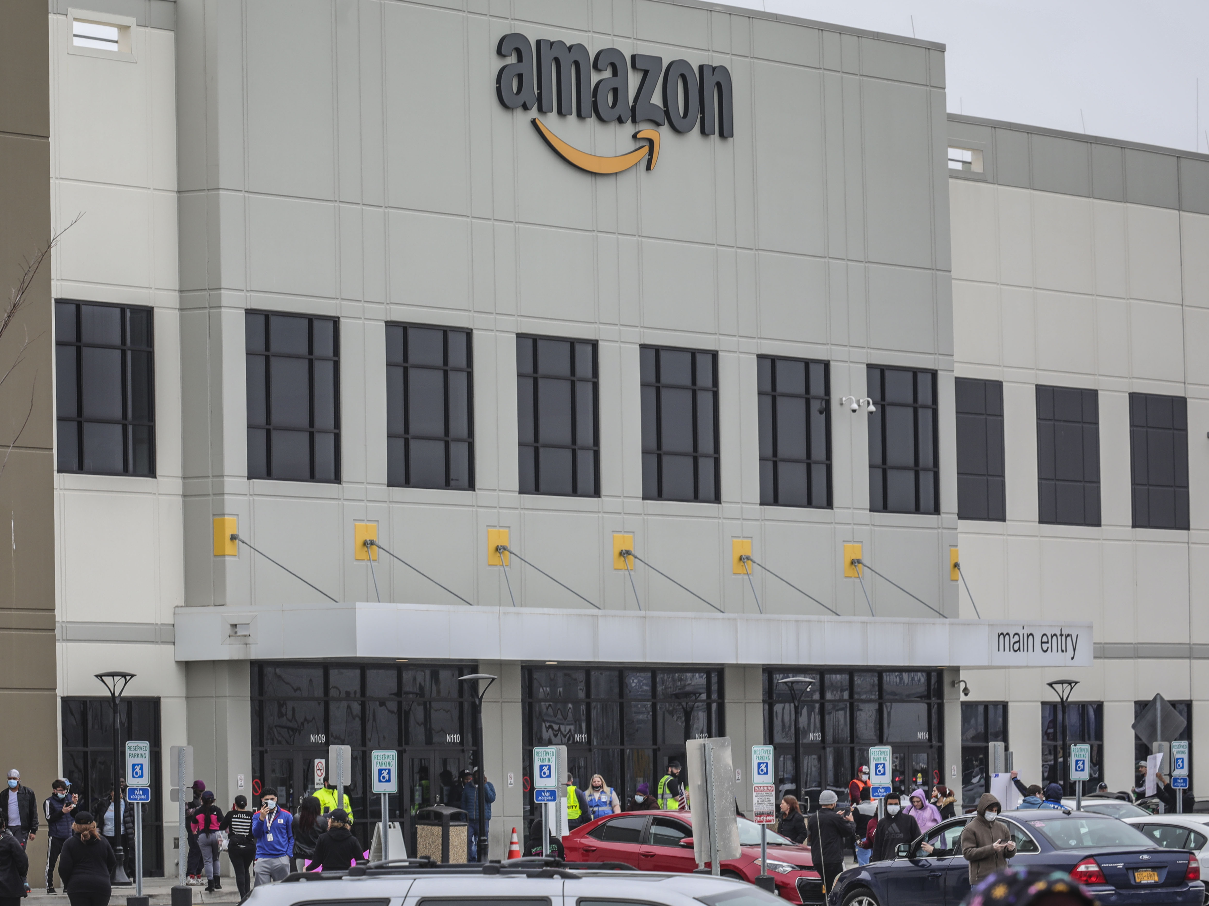 caption: Workers at Amazon's fulfillment center in Staten Island, N.Y., gather outside to protest work conditions on March 30. More protests are being staged around the country this week.