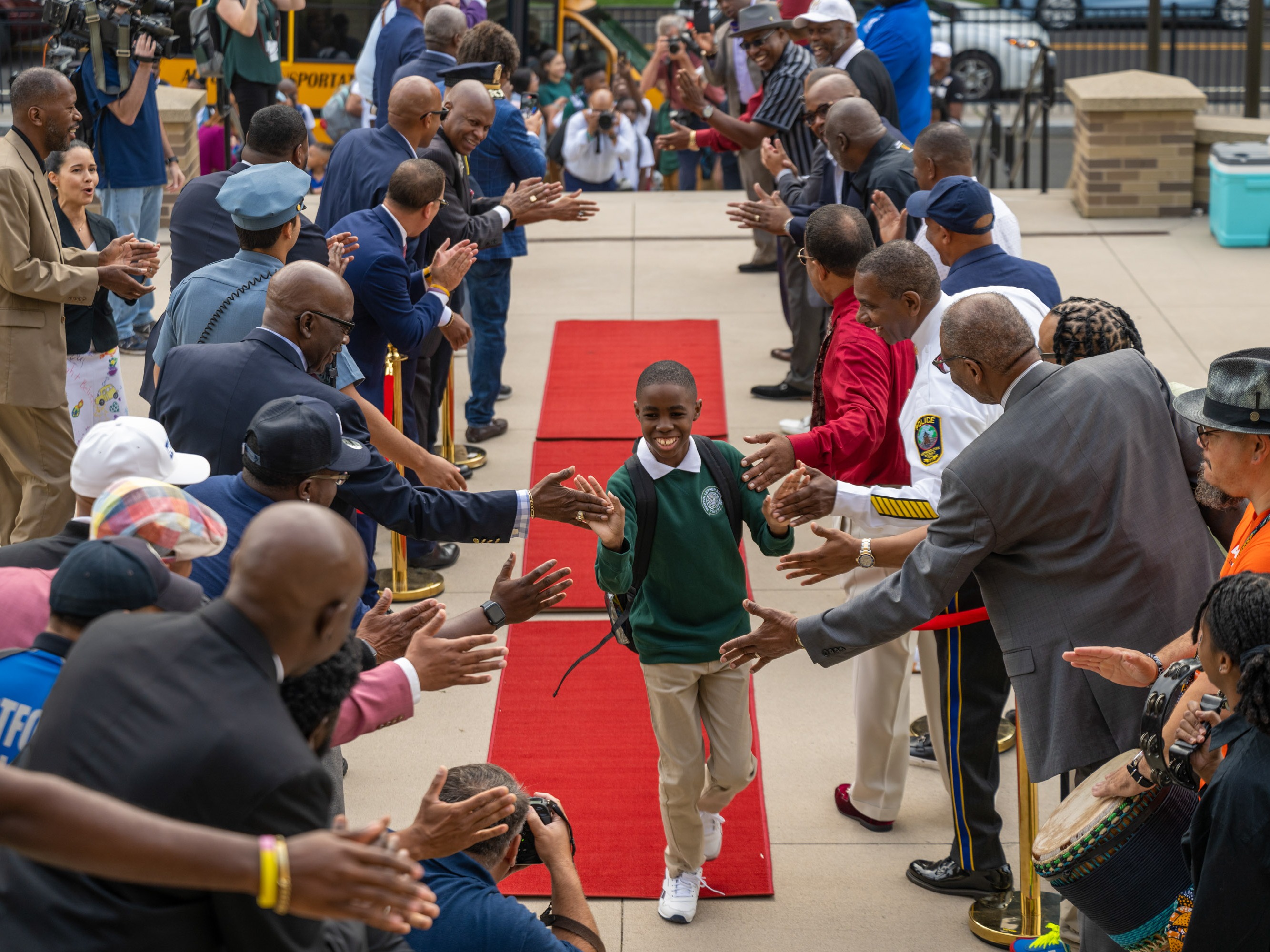 caption: Members of Calling All Brothers welcome the students of Dr. Martin Luther King School of Social Justice and Breakthrough Magnet School to their first day of school in Hartford on August 17, 2024.