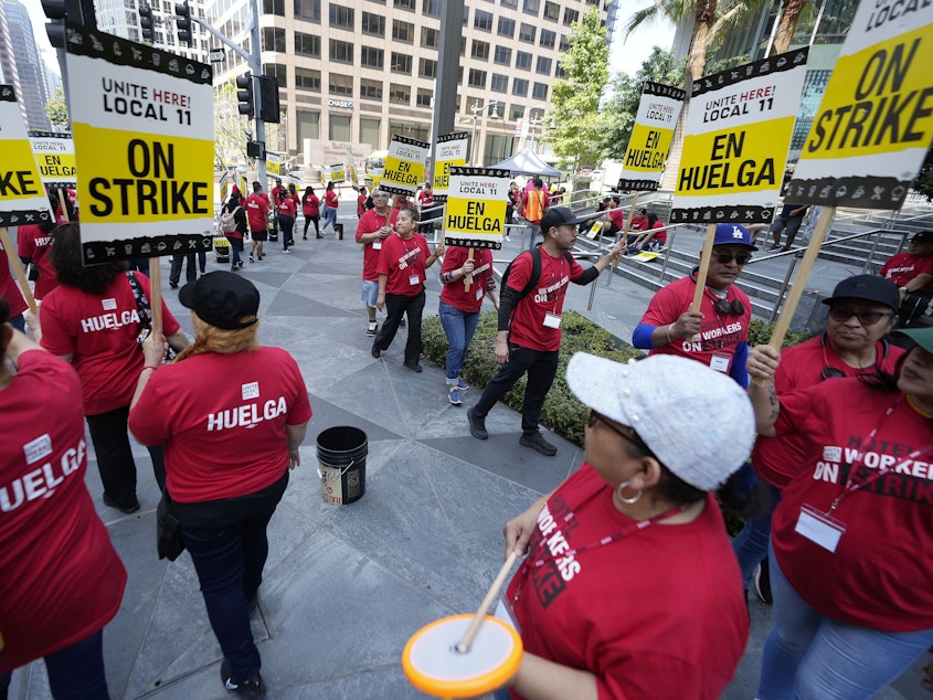 caption: Striking hotel workers rally outside the InterContinental Hotel after walking off their job early Sunday, July 2, 2023, in downtown Los Angeles.