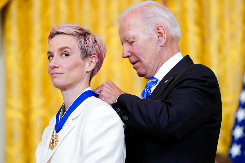 caption: President Joe Biden awards the nation's highest civilian honor, the Presidential Medal of Freedom, to soccer star and Olympic gold medalist Megan Rapinoe during a ceremony in the East Room of the White House in Washington, Thursday, July 7, 2022. Rapinoe is a prominent advocate for gender pay equality, racial justice and LGBTQI+ rights. 
