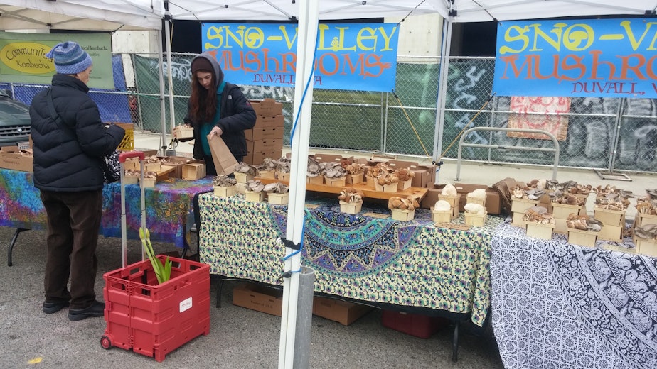 caption: Fran Goldman shops at the University District Farmers Market in Seattle before the 2020 coronavirus pandemic. She stopped doing her own shopping during the pandemic.