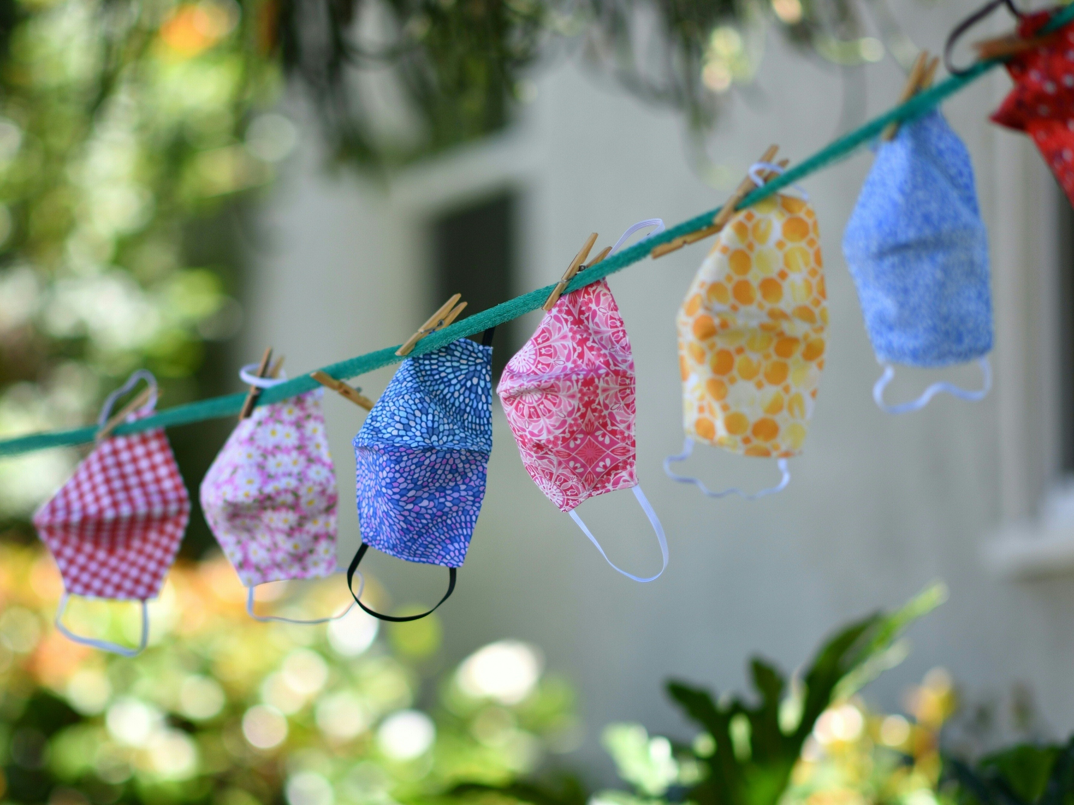 For sale masks are seen displayed on a clothesline in the front yard of a house in Los Angeles on July 20, 2020.