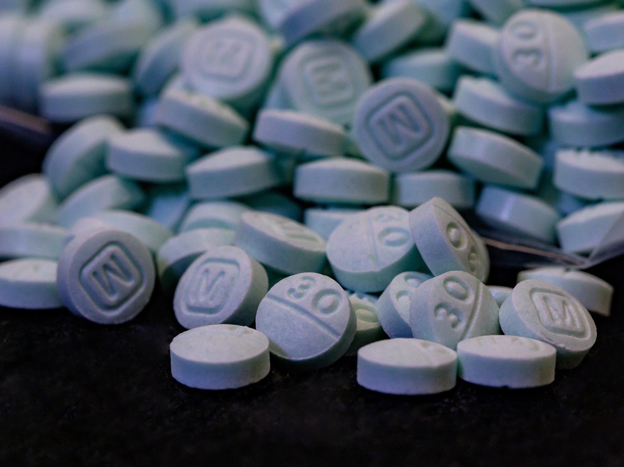 caption: Deputy Attorney General Lisa Monaco said at a news conference in Washington that counterfeit pills are designed to look like regular prescription drugs. Here, counterfeit 30 mg Oxycodone tablets.