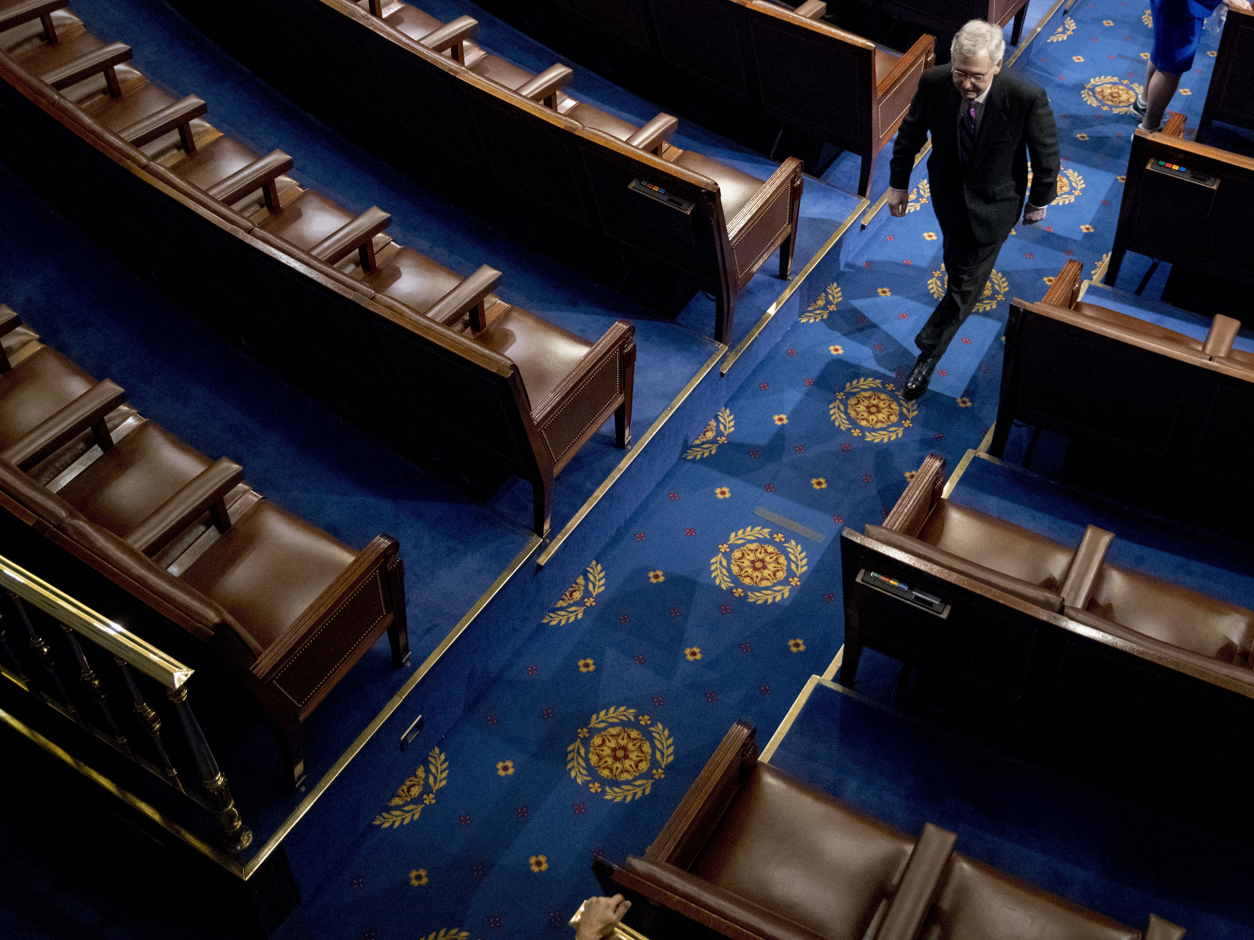 caption: Senate Majority Leader Mitch McConnell of Kentucky walks off the House floor following a speech in April.