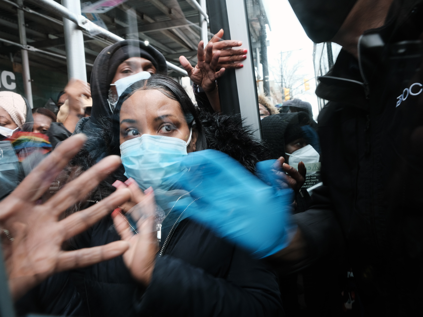 caption: People form a large crowd as they attempt to receive COVID-19 testing kits from city workers distributing the kits along Flatbush Avenue on December 24, 2021 in the Brooklyn borough of New York City. The city is handing out thousands of the kits, which include two tests per box, in order to lesson the surge of people in long lines at testing sites.