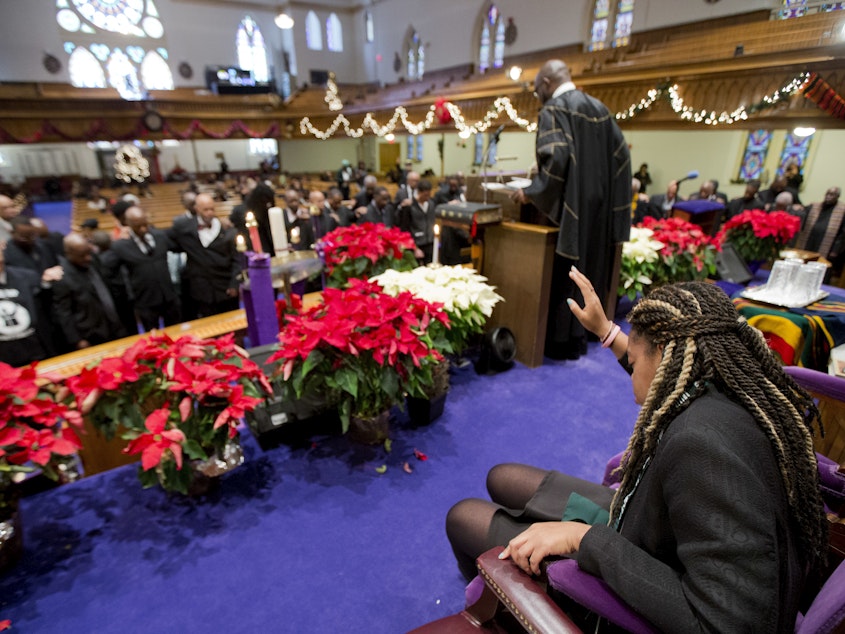caption: Pastor Rev. William Lamar IV leads his congregation in prayers, during a service at the Metropolitan AME Church in Washington, D.C., in 2014.