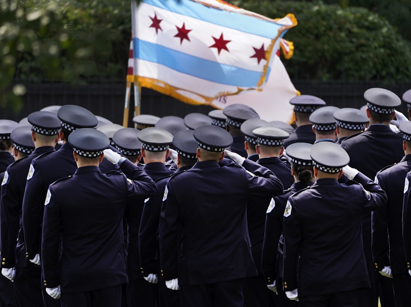 caption: Chicago police officers salute the state flag on Aug. 18.