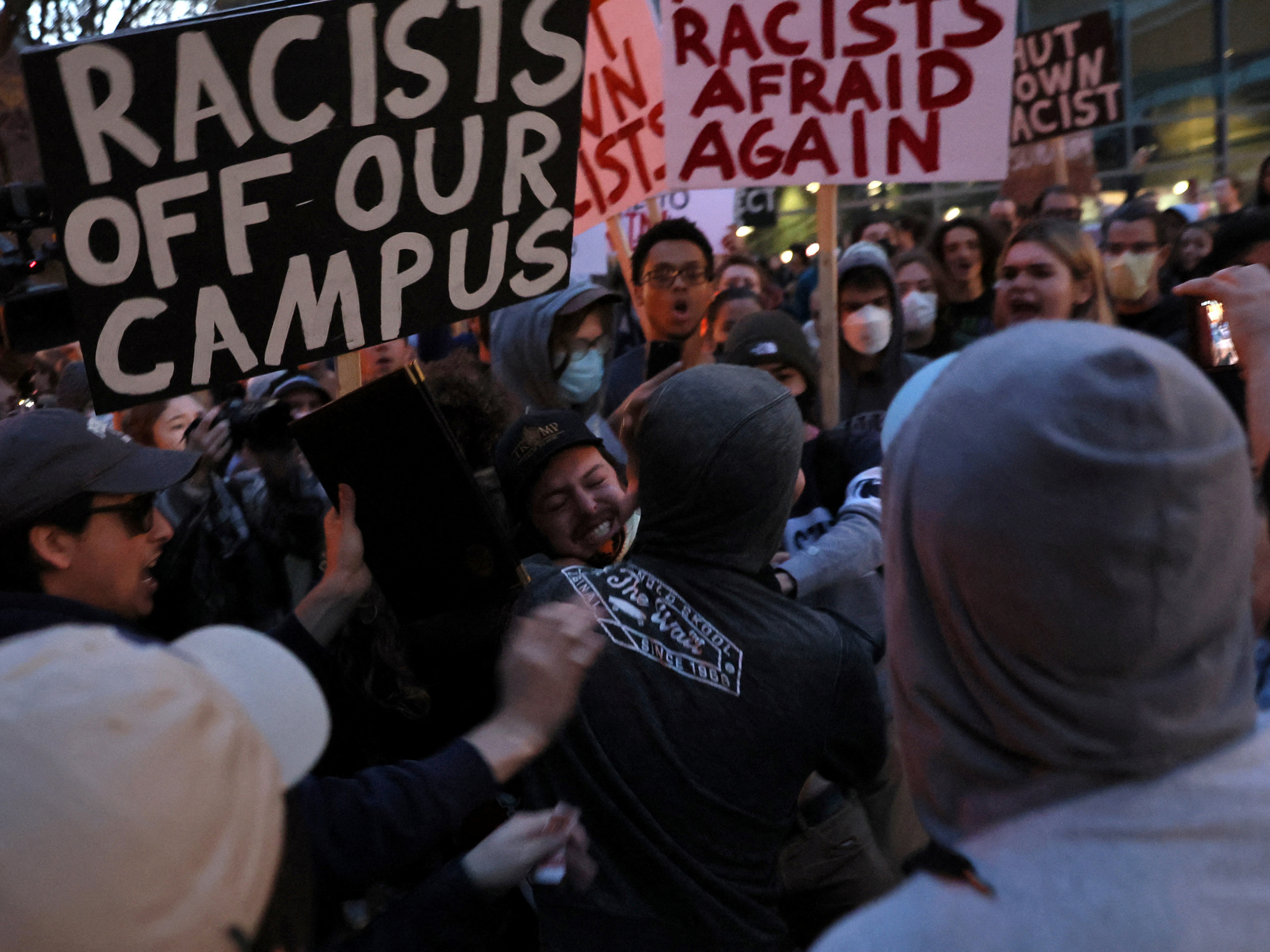 caption: A man wearing a Proud Boys shirt fights with protesters ahead of an event featuring far-right group Proud Boys' founder Gavin McInnes at Pennsylvania State University in State College, Pa., on Monday. The event was canceled by Penn State officials, who cited "the threat of escalating violence."