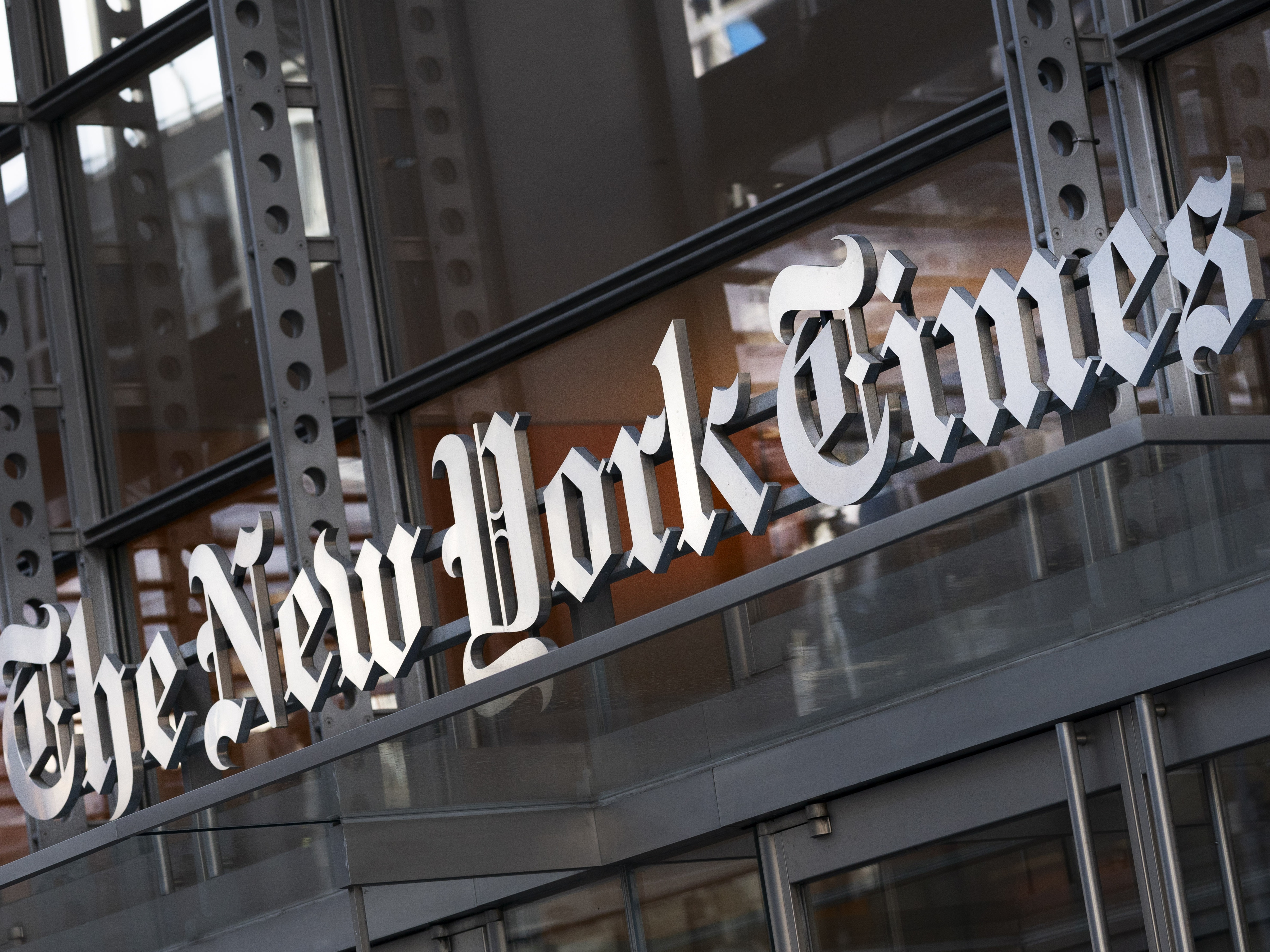 caption: A sign for The New York Times hangs above the entrance to its building, Thursday, May 6, 2021, in New York.  The New York Times filed a federal lawsuit against OpenAI and Microsoft on Wednesday, Dec. 27, 2023, seeking to end the practice of using published material to train chatbots.