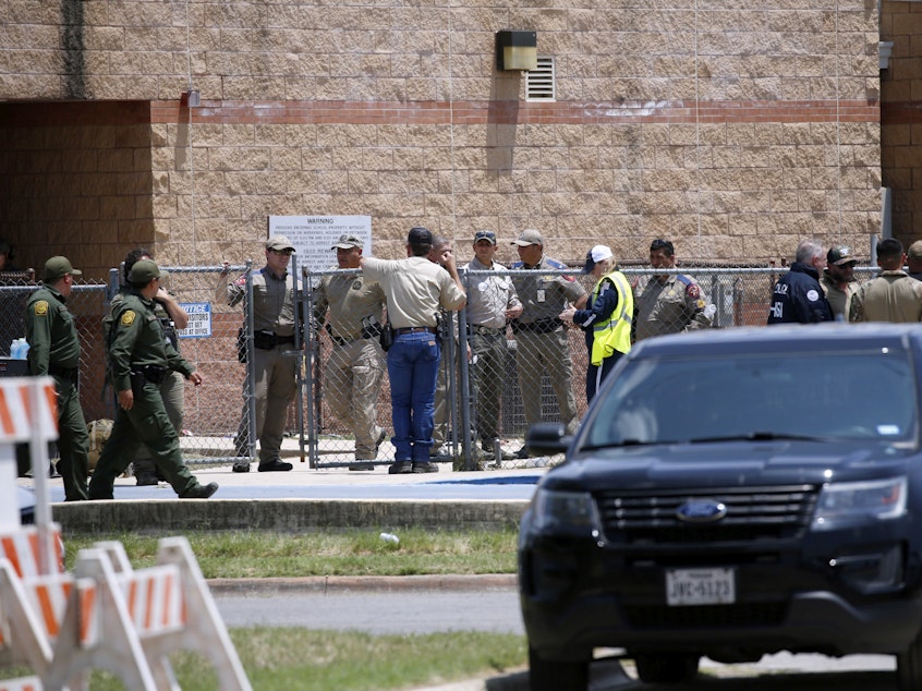 caption: Law enforcement and first responders gather outside Robb Elementary School following Tuesday's shooting in Uvalde, Texas. Their response has since come under wide scrutiny.