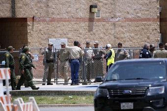 caption: Law enforcement and first responders gather outside Robb Elementary School following Tuesday's shooting in Uvalde, Texas. Their response has since come under wide scrutiny.