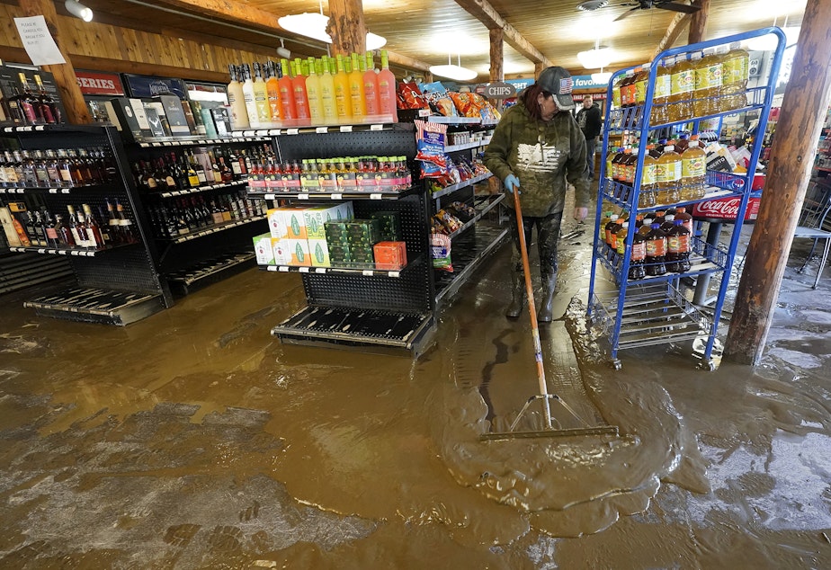 caption: Laura Anker cleans up mud from flooding at the Cherry Street Market, Wednesday, Nov. 17, 2021, in Sumas, Wash. An atmospheric river—a huge plume of moisture extending over the Pacific and into Washington and Oregon—caused heavy rainfall in recent days, bringing major flooding in the area. 