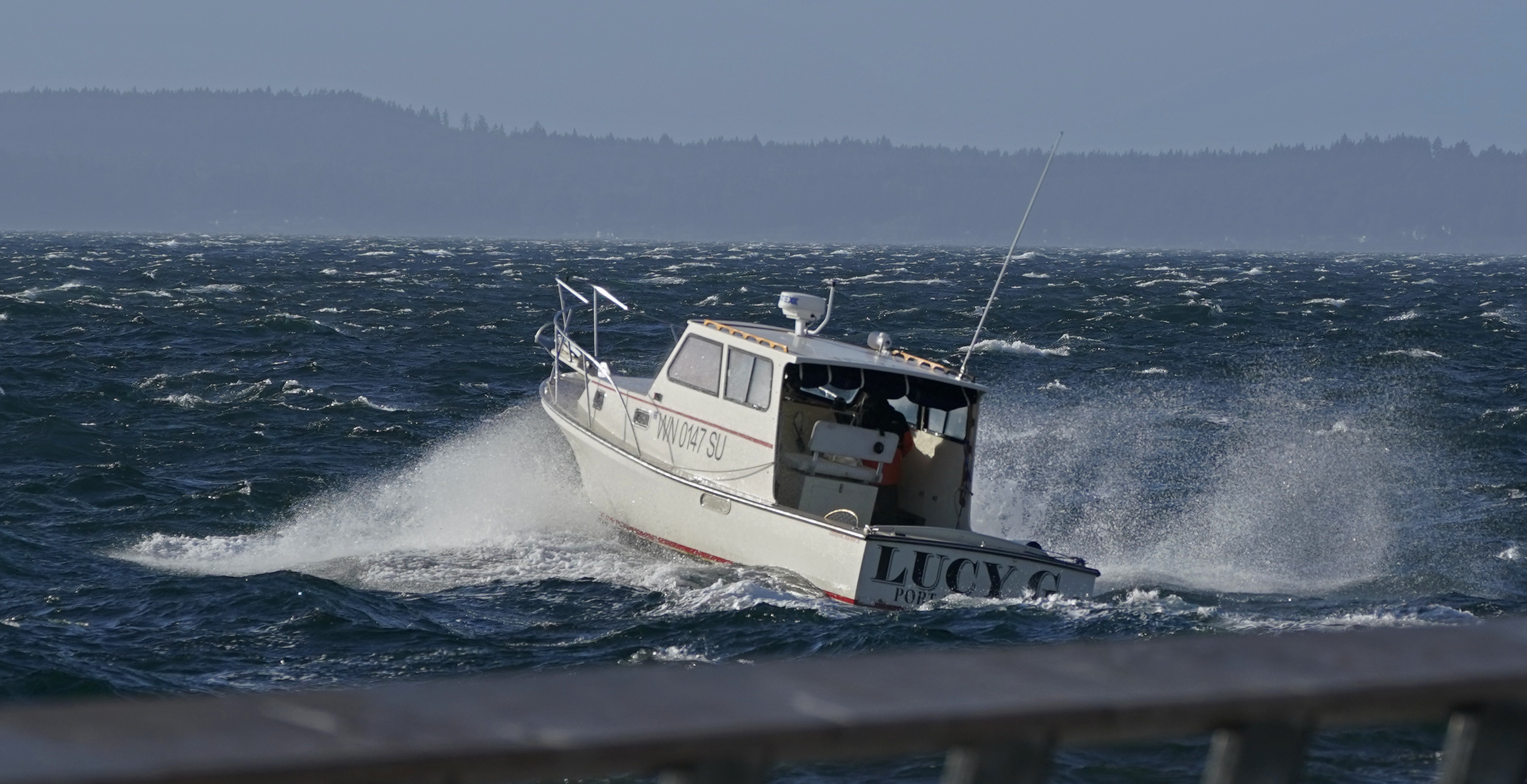 caption: A boat makes its way through rough seas in Elliott Bay, Tuesday, Oct. 13, 2020, in Seattle. 