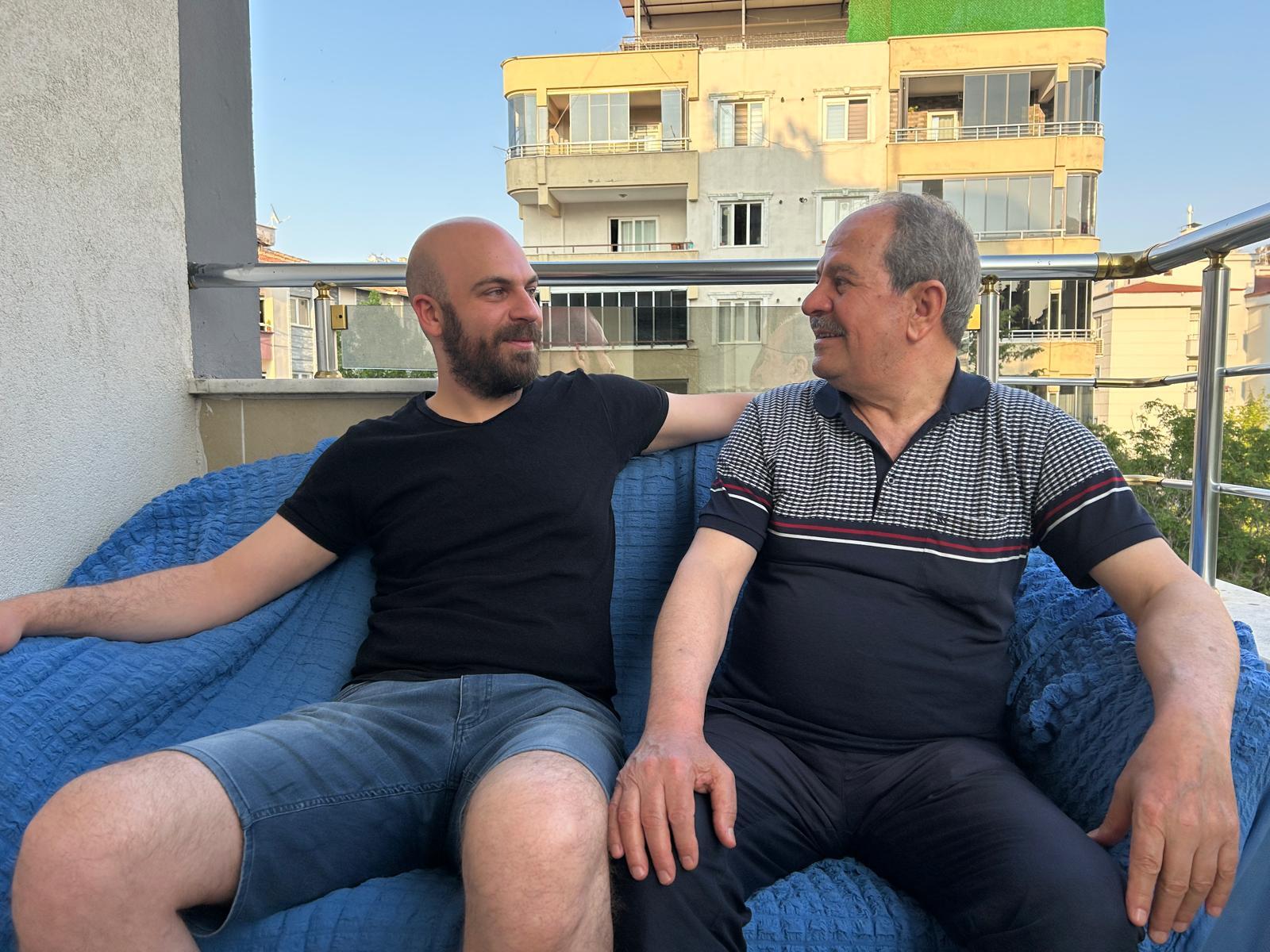 caption: Adham Aljamous, 32, and his father Nouruldeen, 72, on their rooftop in Gaziantep, Turkey. They fled Syria over a decade ago. Now, with a chance to return, they're unsure what's left of home.