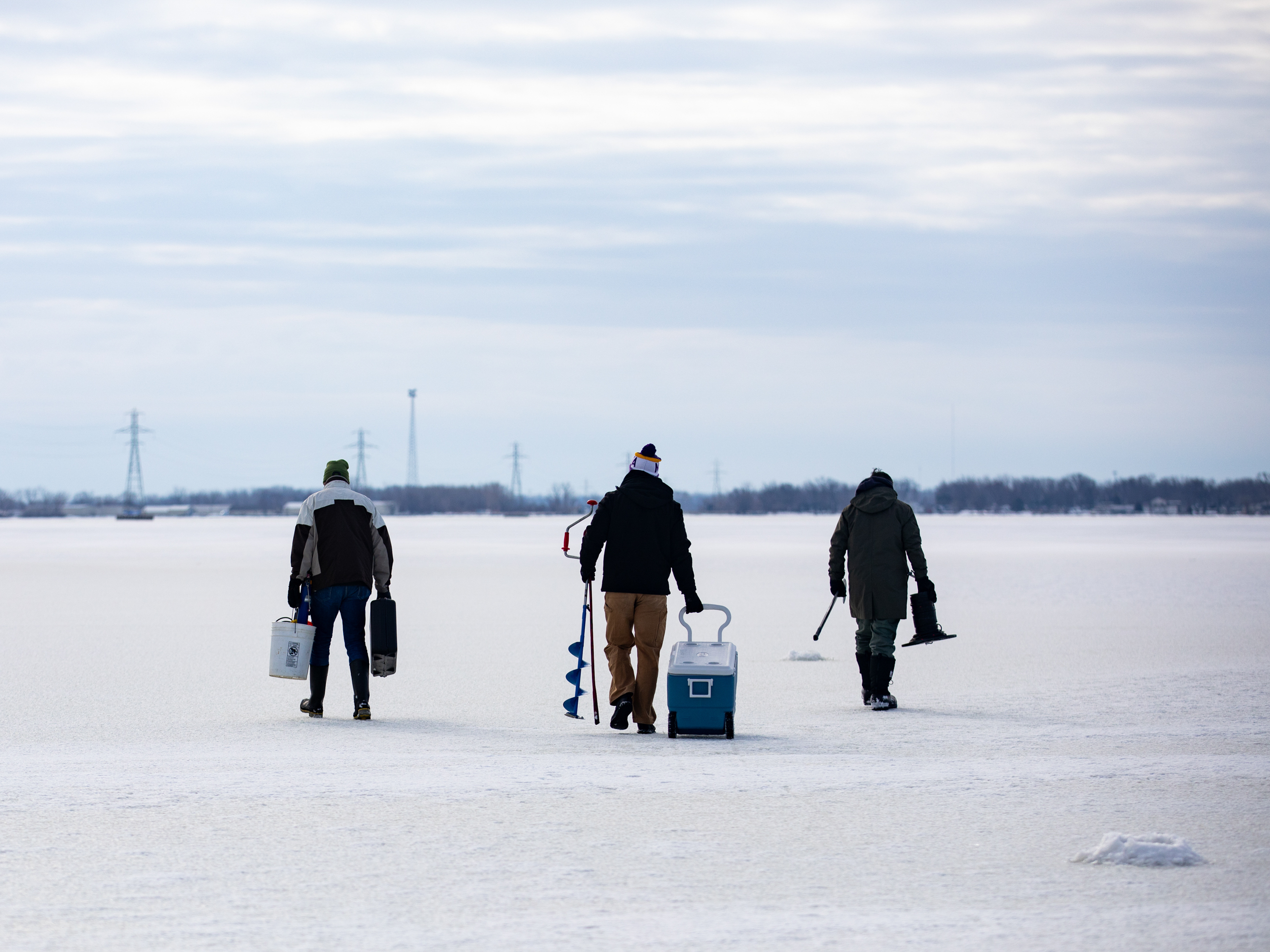 caption: From left: Bowling Green State University emeritus biology professor George Bullerjahn, Bowling Green graduate student Ryan Wagner and University of Windsor professor Mike McKay set out on the frozen surface of Lake Erie's Sandusky Bay to find a spot to collect water samples on Feb. 9 near Port Clinton, Ohio.