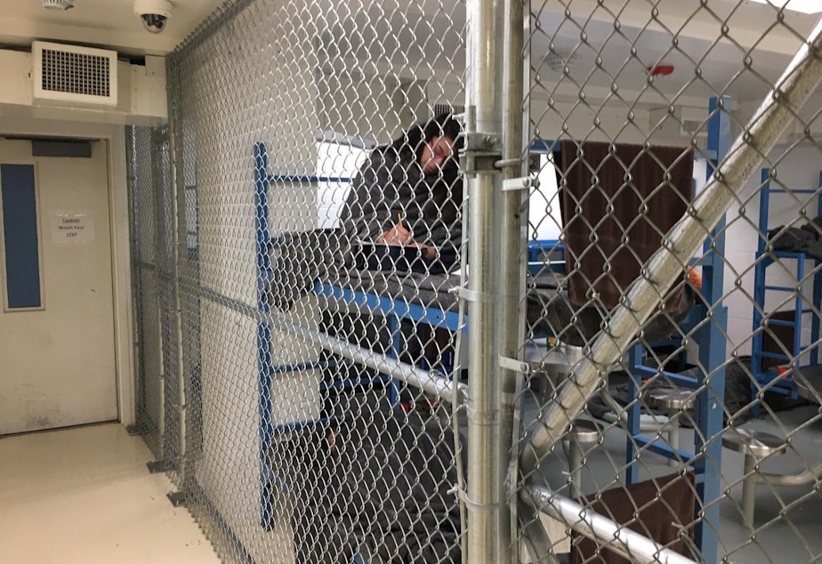 caption: Women inmates at the Mason County Jail in Shelton, Washington are held behind chain link fencing and given extra blankets to ward off the cold. One inmate said the nickname for the unit is the "dog kennel."