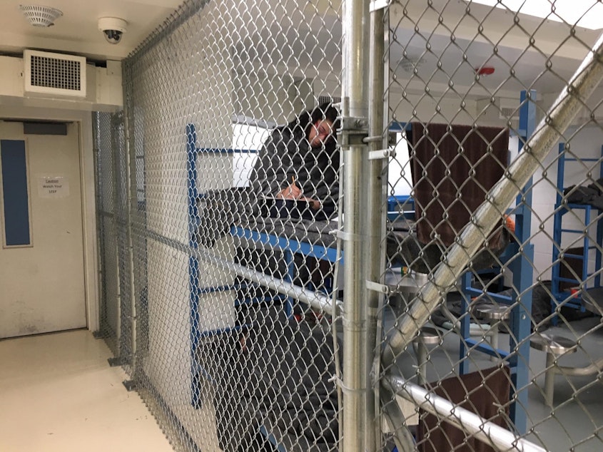 caption: Women inmates at the Mason County Jail in Shelton, Washington are held behind chain link fencing and given extra blankets to ward off the cold. One inmate said the nickname for the unit is the "dog kennel."