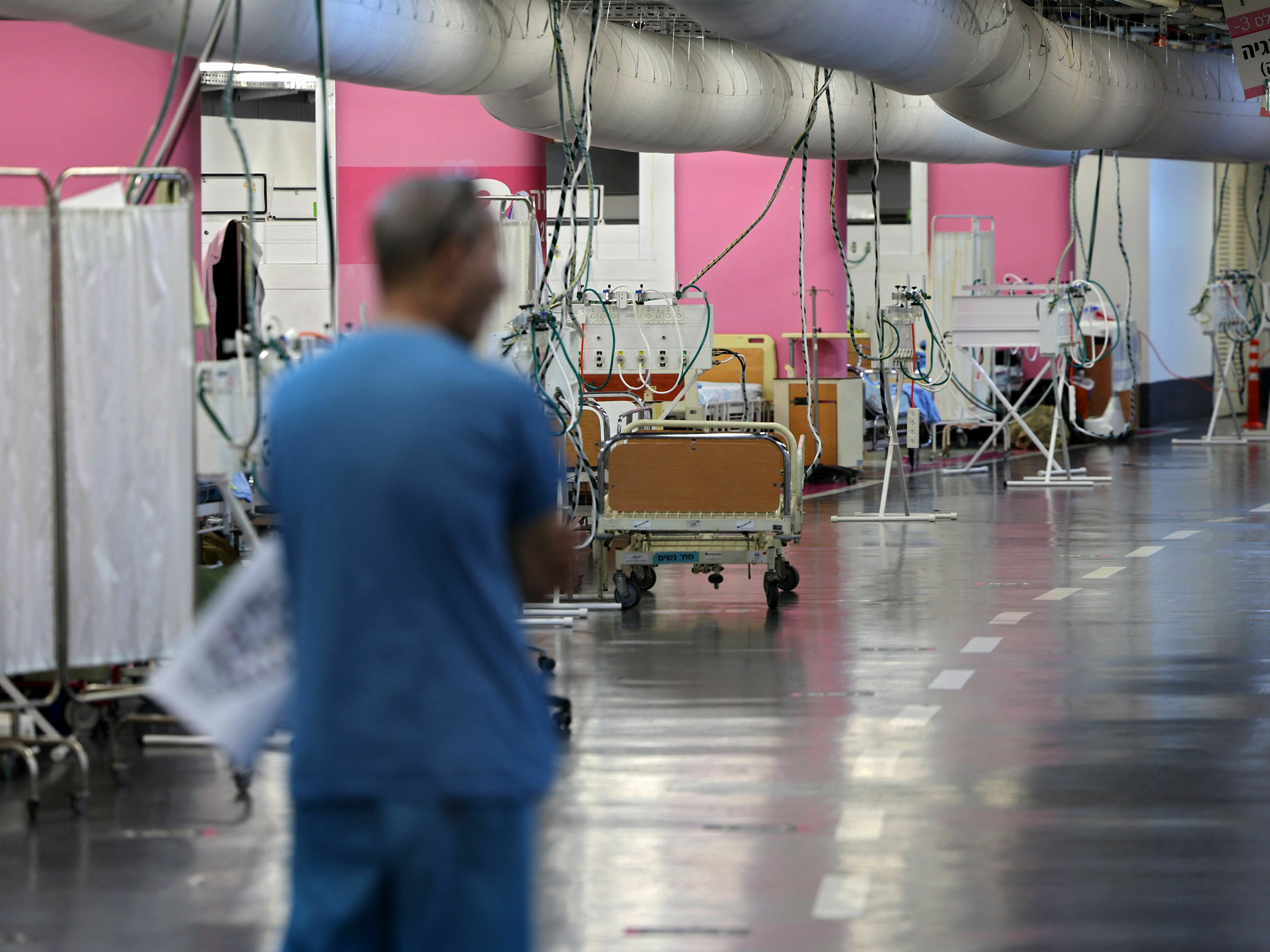 caption: A man walks through a makeshift emergency underground hospital in the parking lot of the Rambam Health Care Campus (RHCC) in Haifa in northern Israel.
