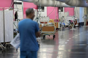 caption: A man walks through a makeshift emergency underground hospital in the parking lot of the Rambam Health Care Campus (RHCC) in Haifa in northern Israel.