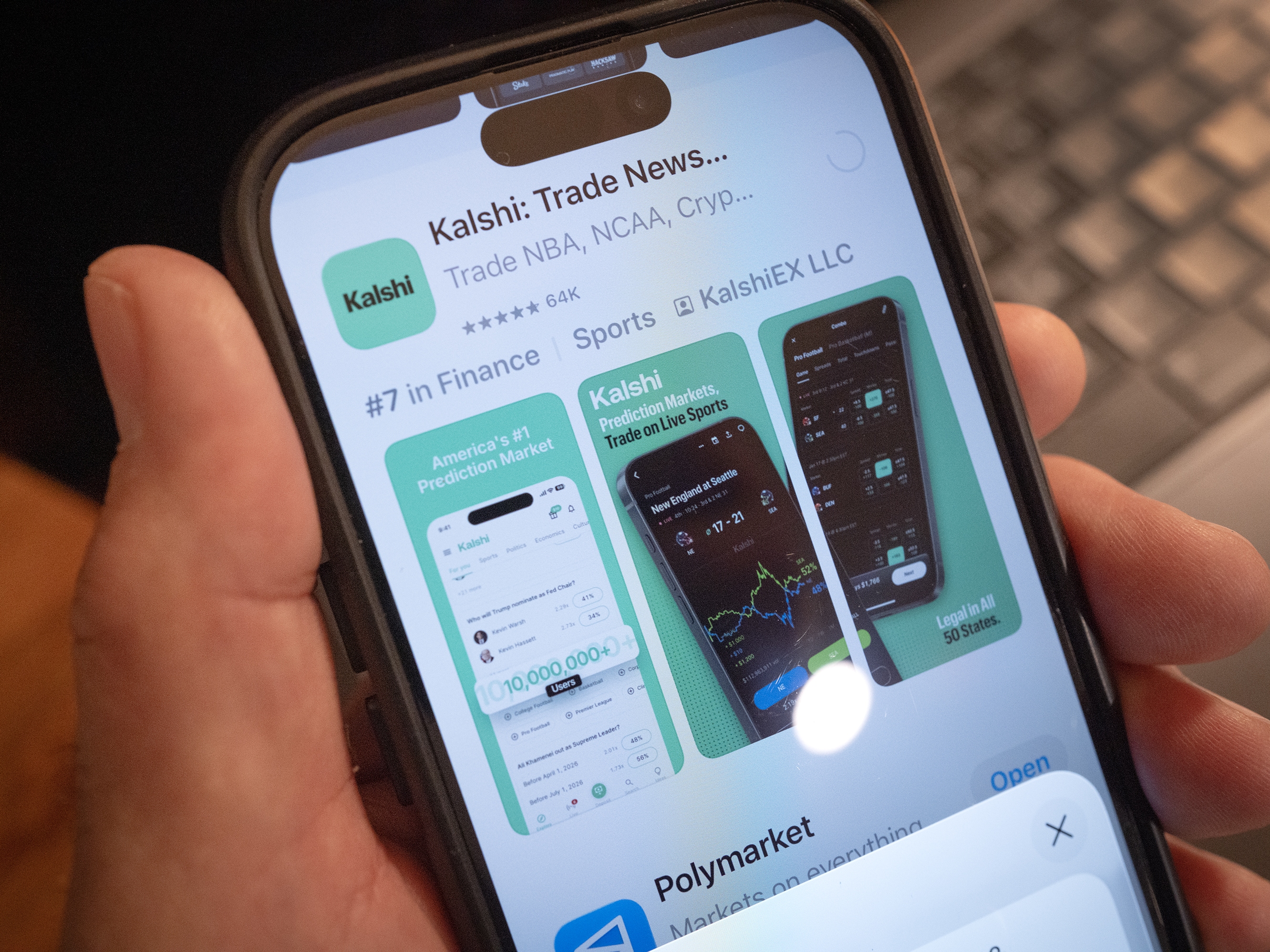 caption: An app for Kalshi, an online prediction market site, is shown on a phone. Multiple states have tried to block the company from operating, citing state gambling laws. But the federal government has sued to block those state laws to allow Kalshi and other prediction markets to operate.