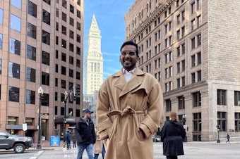caption: Pragadish Kalaivanan, a marketing analyst, got up extra early to dress for work before his first days back at the office in Boston. He's among those happy to still be able to work two days from home, as the company's new hybrid policy allows.