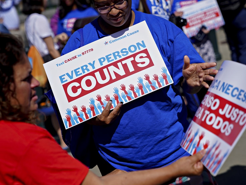 caption: A demonstrator hands out a sign about the 2020 census outside the U.S. Supreme Court in Washington, D.C., in 2019. The Census Bureau is projecting the first set of census numbers won't be ready until February, Trump administration attorneys told a federal judge on Monday.