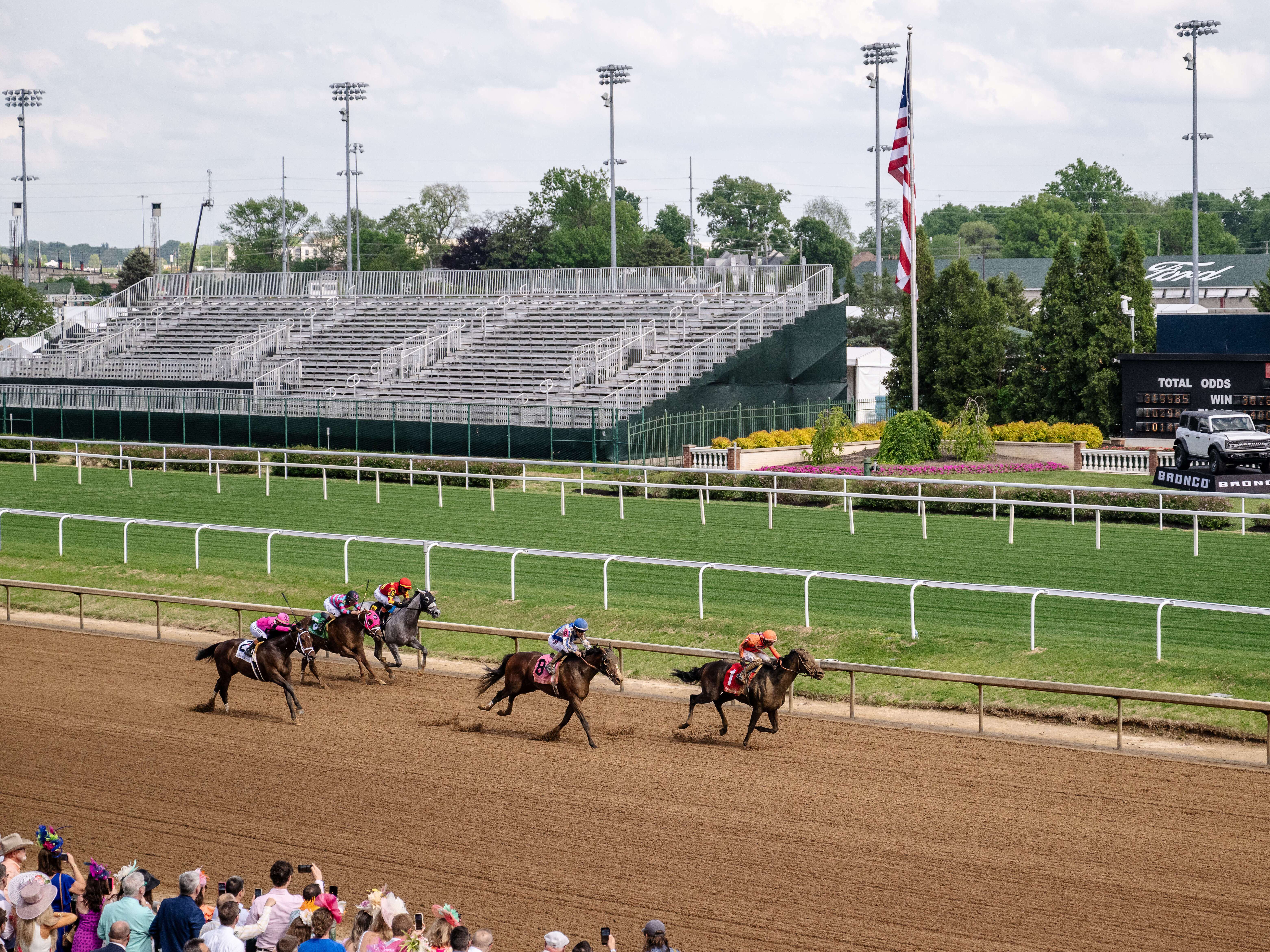 caption: Spectators watch a horse race at Churchill Downs in Louisville, Ky., on April 30, 2025. Junior Alvarado, a jockey from Venezuela, makes his way to second place before crossing the finish line.