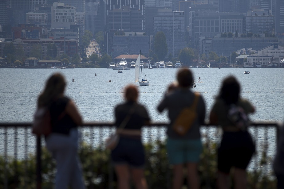 caption: People take pictures of Seattle's skyline on Thursday, August 12, 2021, at Gas Works Park in Seattle. With temperatures forecasted to be in the mid-90s, cooling centers have reopened across Seattle for people to get out of the heat. 