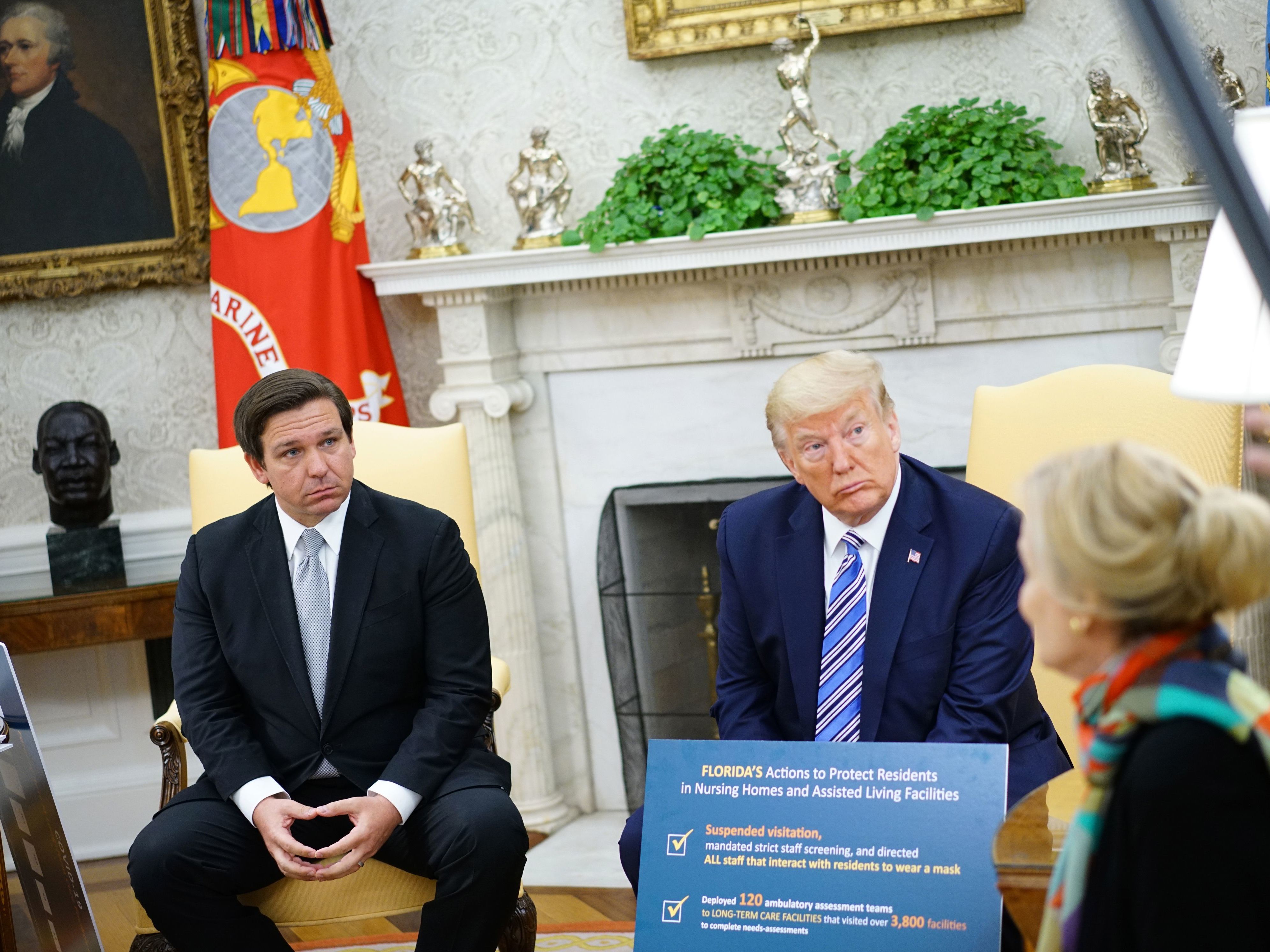 caption: Gov. Ron DeSantis, pictured during a meeting with President Trump on Tuesday, has announced plans to reopen businesses in Florida.
