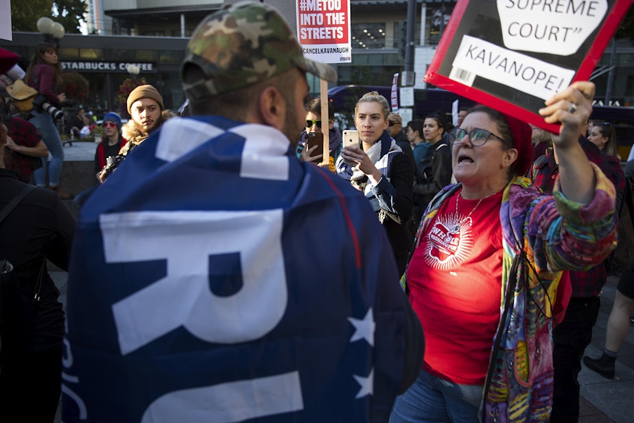 caption: Kathryn Lewandowsky, right, and Armen, left, a member of the UW College Republicans, speak during the 'Cancel Kavanaugh - We Believe Survivors' march and rally on Thursday, October 4, 2018, at Westlake Park in Seattle.