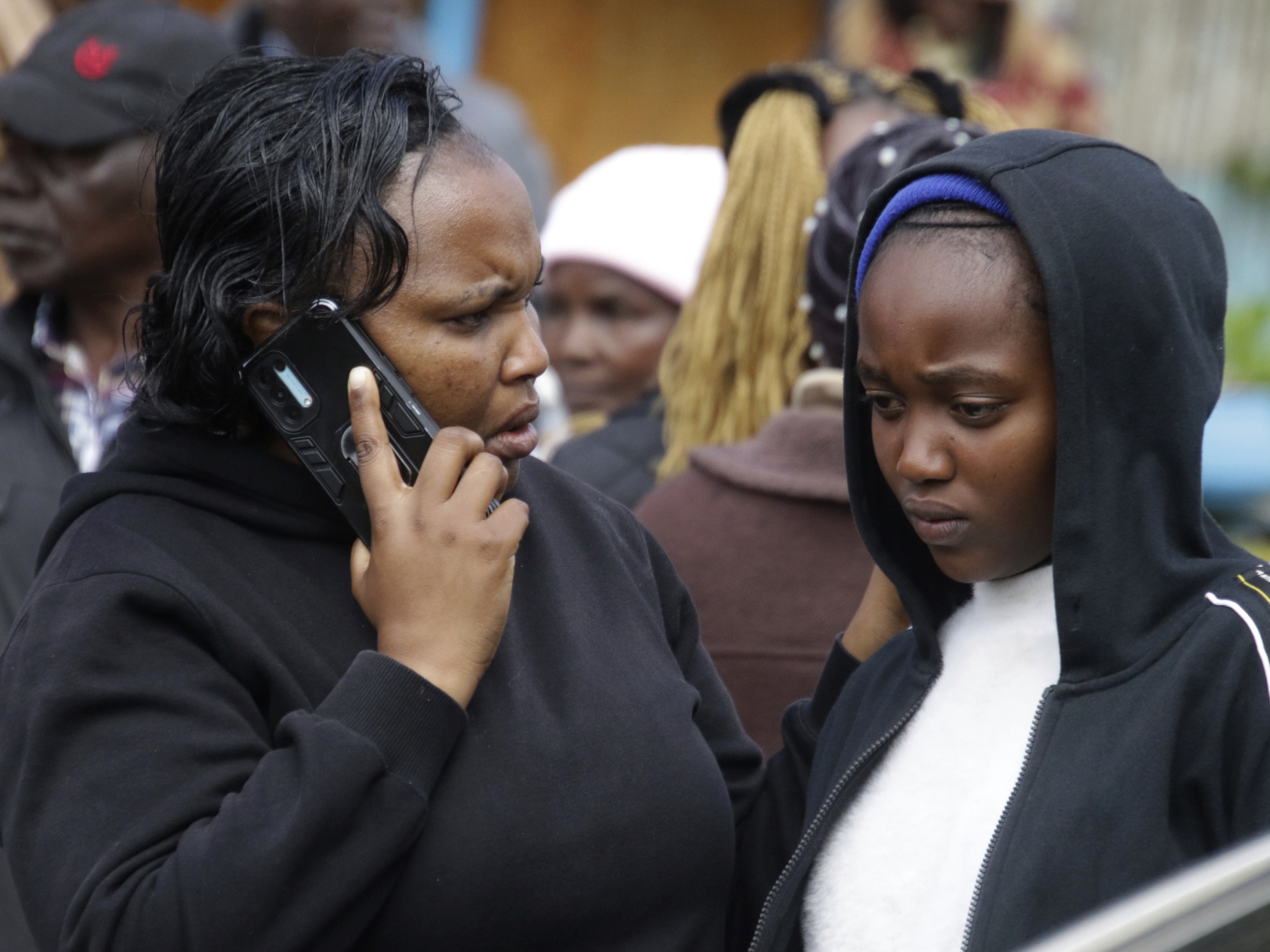 caption: Distressed parents and relatives stand near a burned-out dormitory, following a fire at the Hillside Endarasha Primary in Nyeri, Kenya Friday, Sept. 6, 2024. (AP Photo)