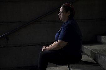 caption: A woman who works the overnight janitorial shift sits for a portrait at 2:13 a.m. on Thursday, June 13, 2019, in downtown Seattle.