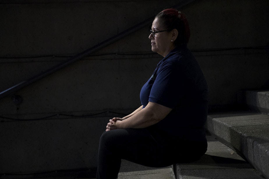 caption: A woman who works the overnight janitorial shift sits for a portrait at 2:13 a.m. on Thursday, June 13, 2019, in downtown Seattle.