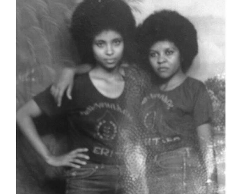 caption: Akberet Asfaha (right) poses with her best friend and fellow soldier, Amna Mohammad. Akberet left home at age 16 without her parents' permission to fight in the Eritrean War of Independence.