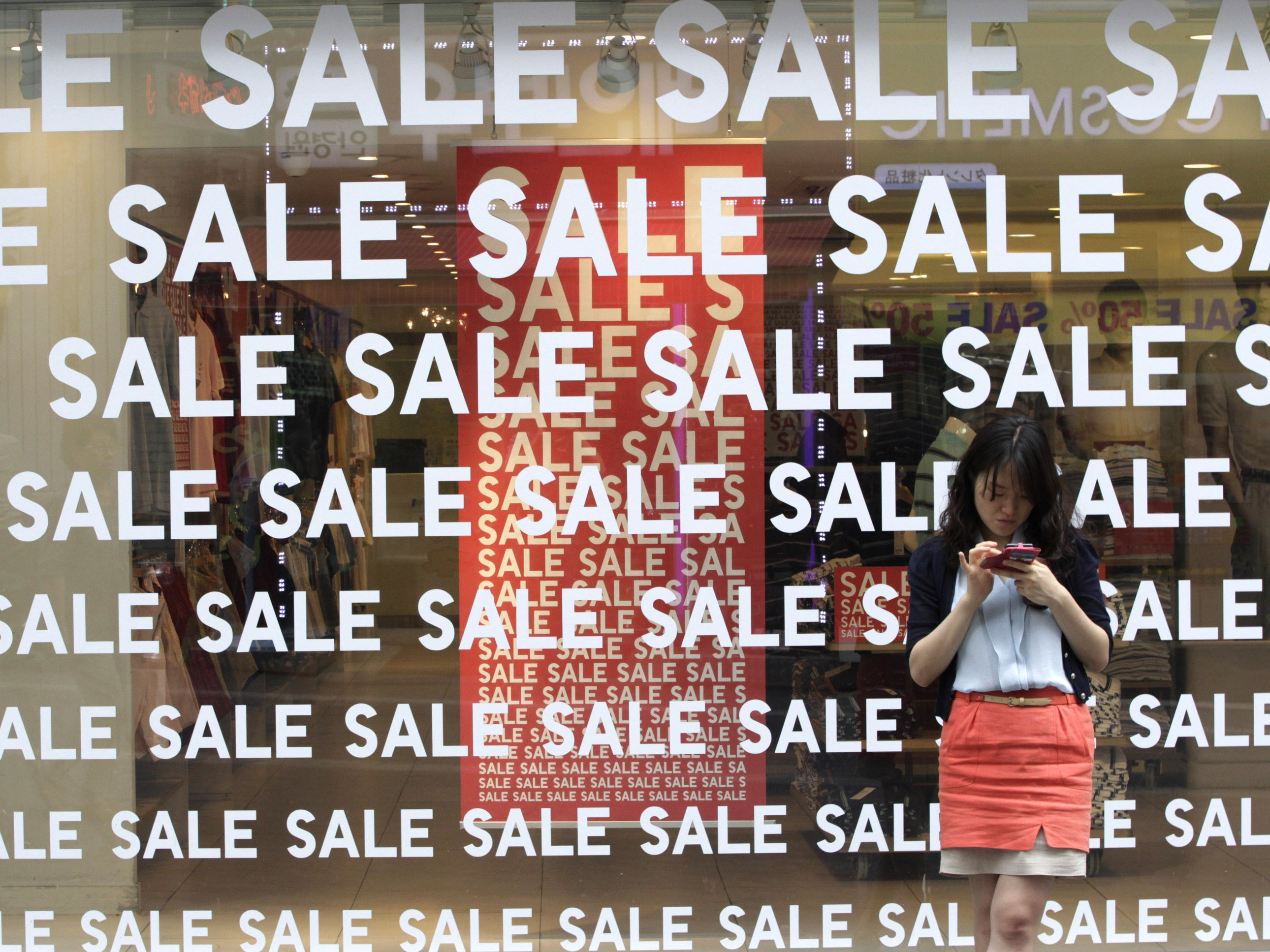 A woman stands in front of a store in Seoul in 2012.